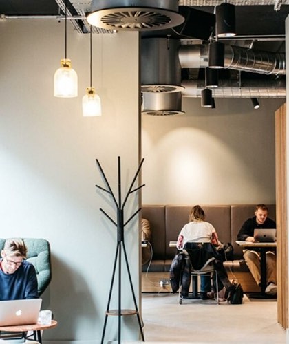 The Projects Brighton, co-working space with people working in booths and industrial lighting overhead.