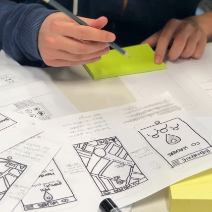 Hands sketching early design concepts on paper and post-it notes.