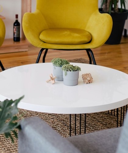 Relaxed meeting space with a yellow chair and white coffee table.